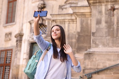 Photo of Beautiful travel blogger with smartphone streaming outdoors
