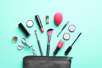 Photo of Makeup products with cosmetic bag on color background