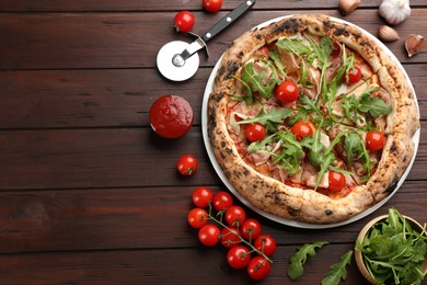 Photo of Tasty pizza with meat and arugula on wooden table, flat lay. Space for text