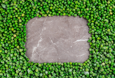 Photo of Frame made with frozen peas on brown marble table, top view. Space for text