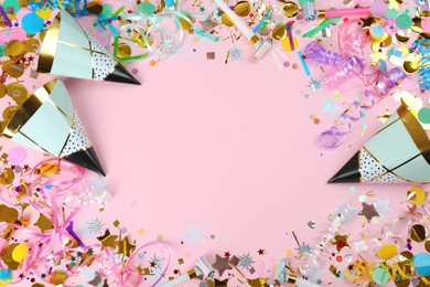 Photo of Frame of colorful serpentine streamers and other party accessories on pink background, flat lay. Space for text