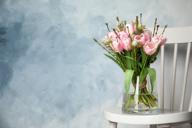 Photo of Beautiful bouquet with spring pink tulips on white chair. Space for text