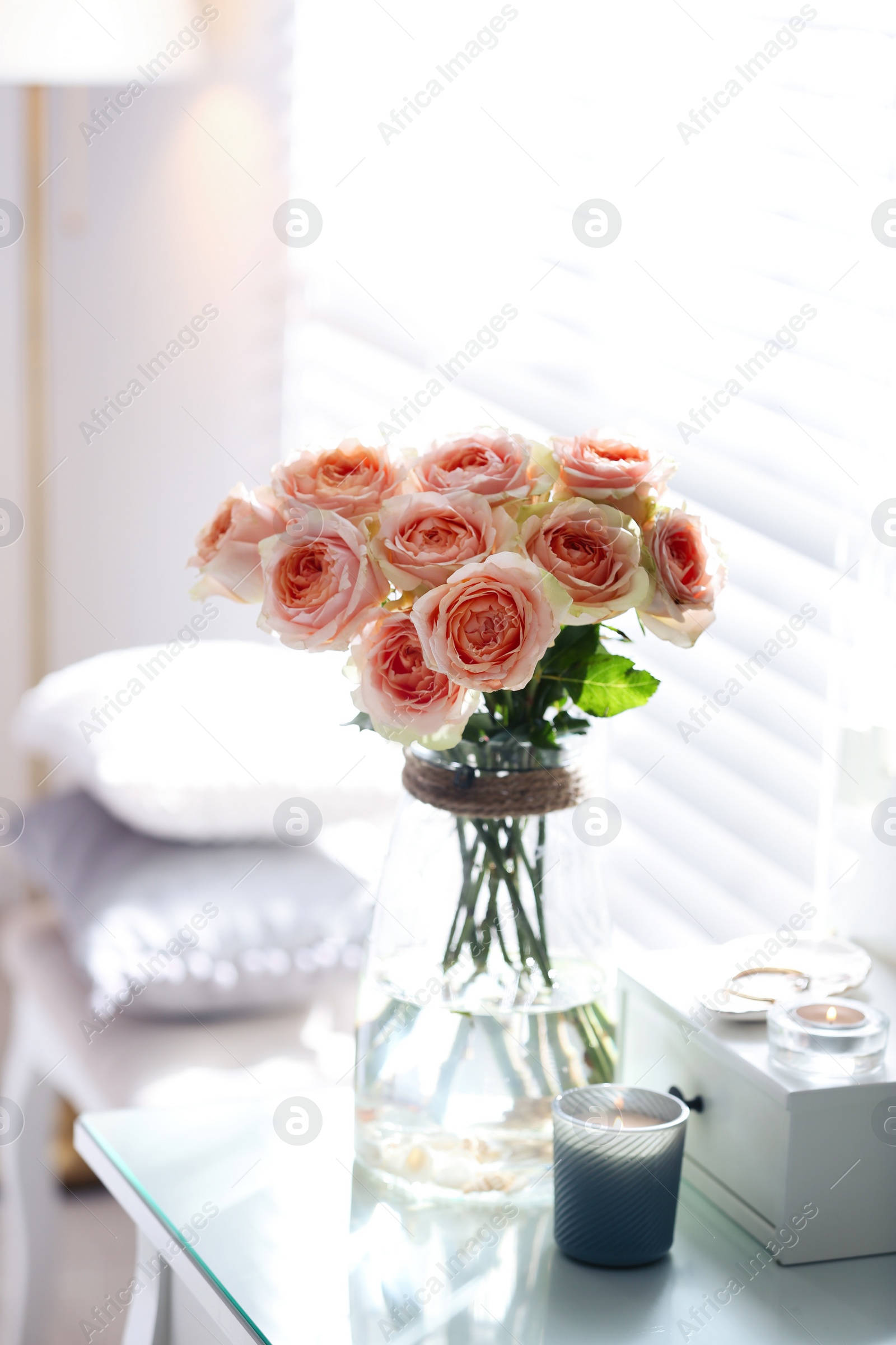 Photo of Glass vase with beautiful flowers on dressing table in modern room interior