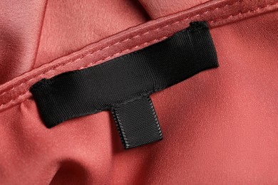 Photo of Clothing labels on beautiful garment, top view