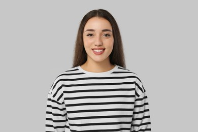 Portrait of beautiful young woman on light grey background