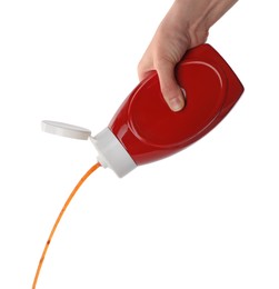 Photo of Woman pouring tasty ketchup from bottle on white background, closeup