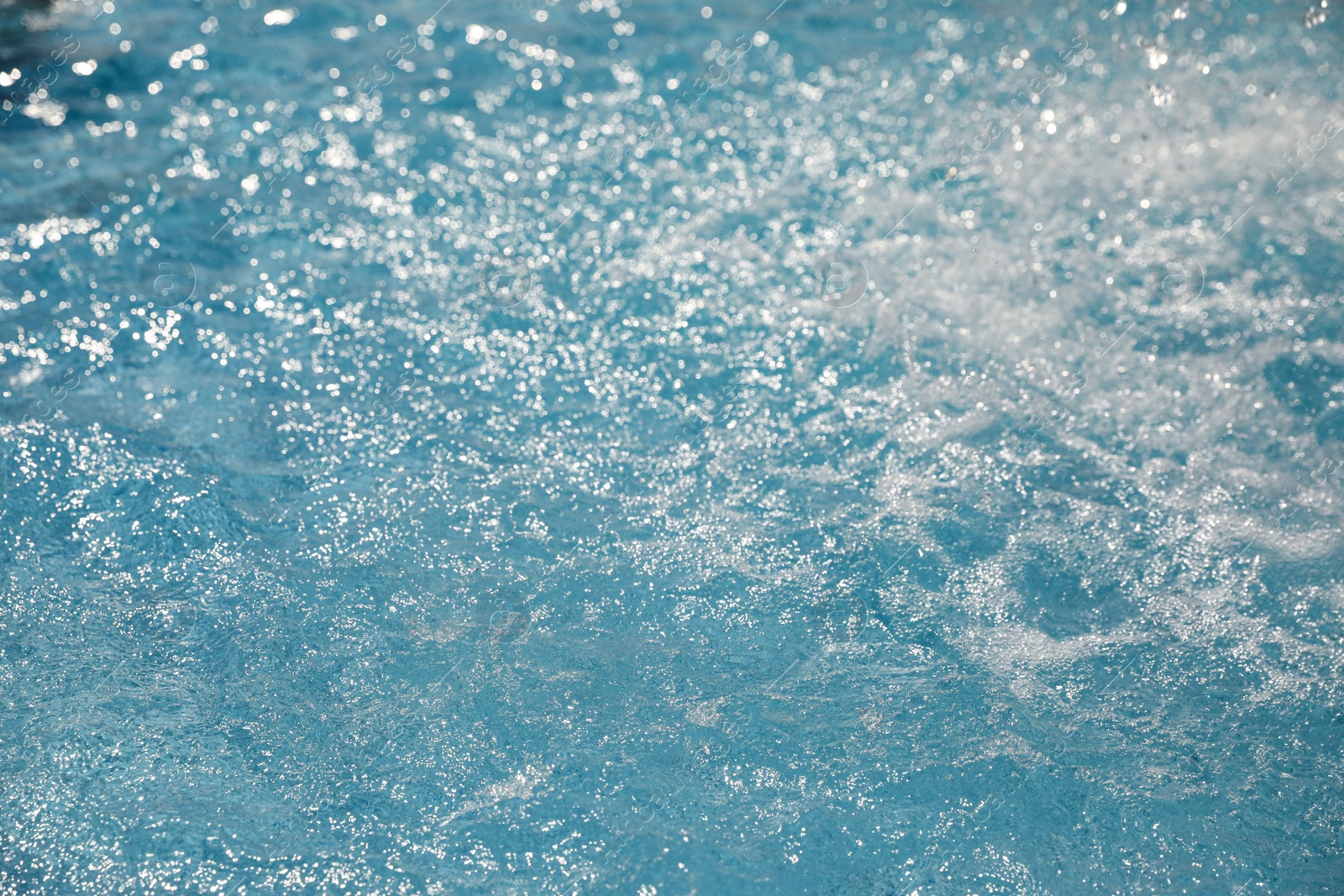 Photo of Splashes in swimming pool on sunny day. Summer vacation