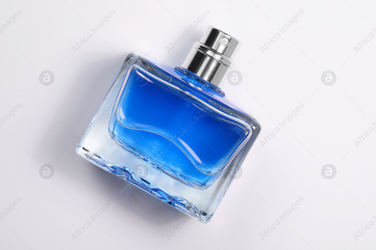 Photo of Blue men's perfume in bottle on white background, top view