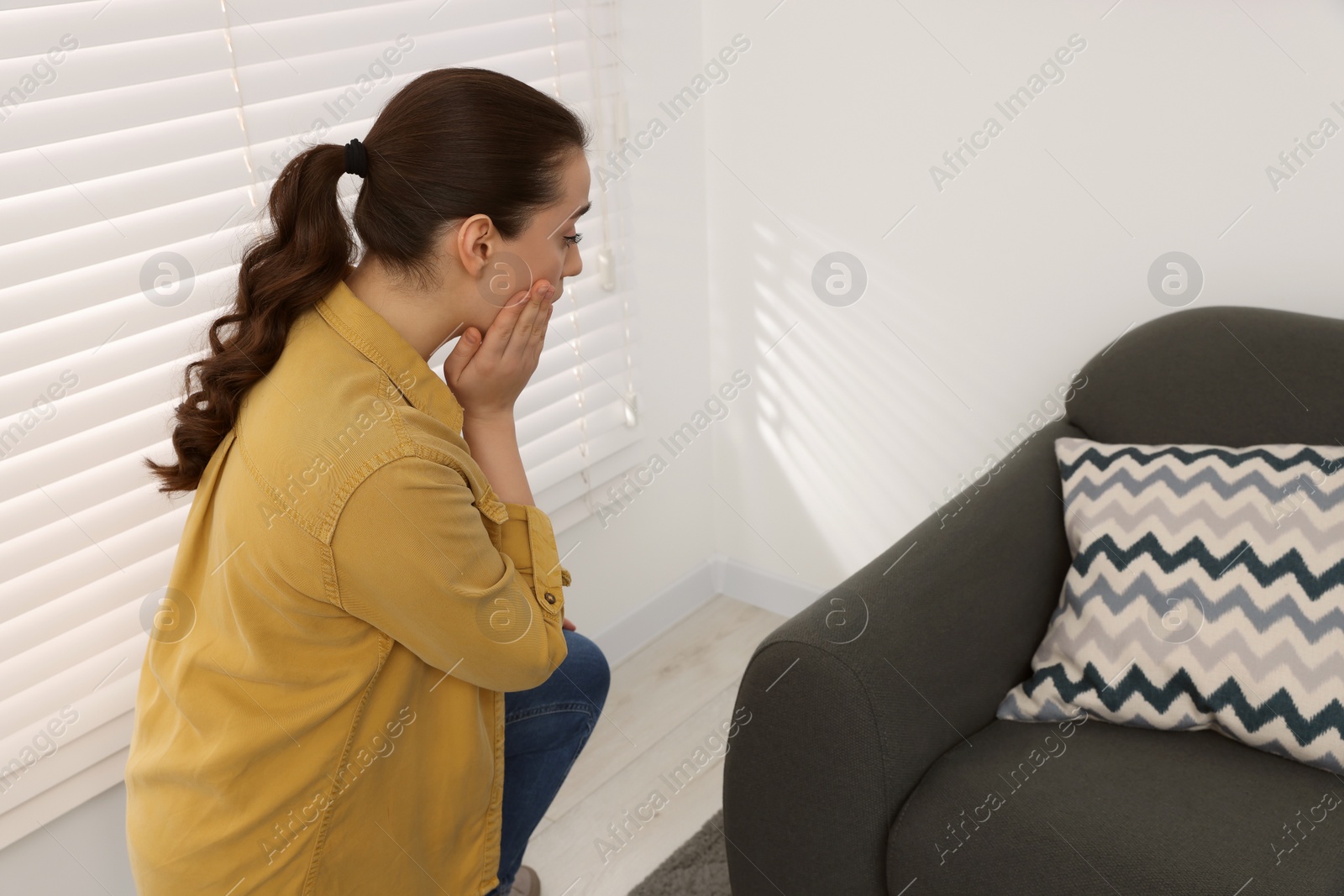 Photo of Confused woman looking at white wall in room