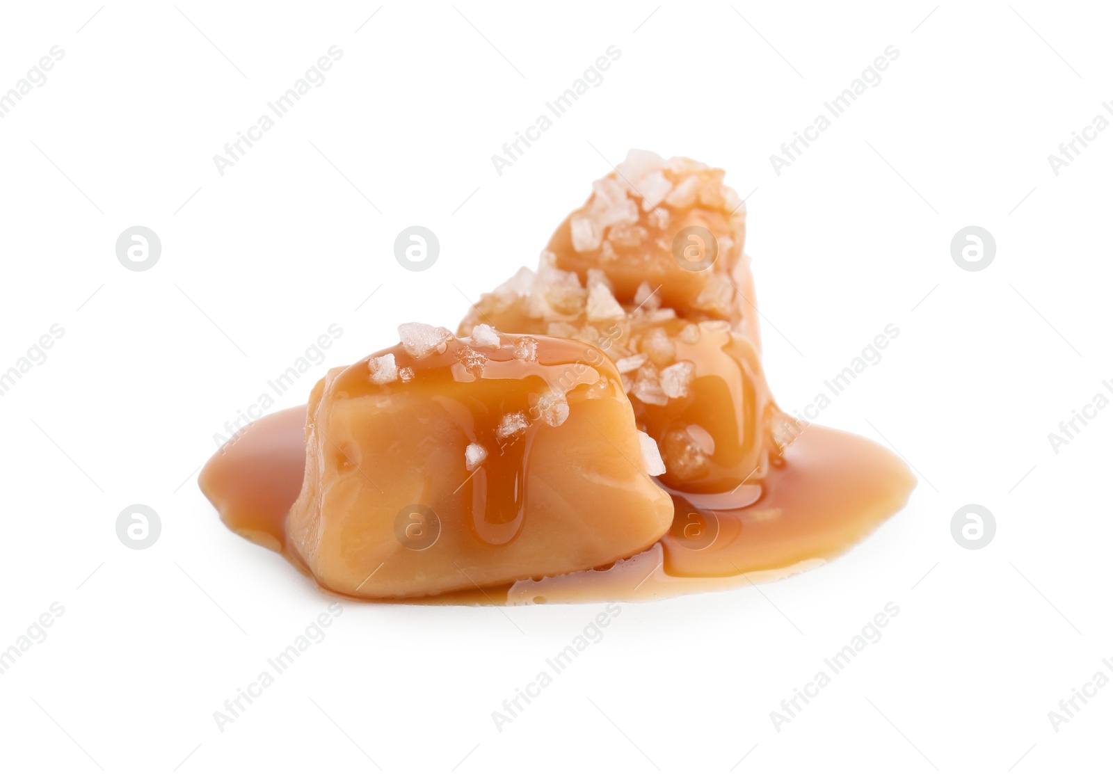 Photo of Yummy caramel candies and sea salt isolated on white