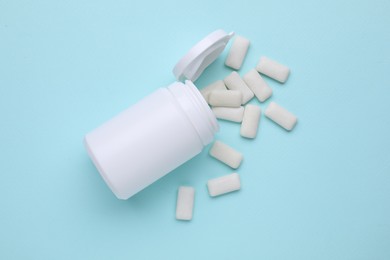 Photo of Jar with chewing gums on light blue background, flat lay