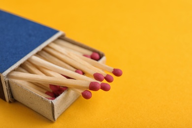 Photo of Cardboard box with matches on color background, closeup. Space for text