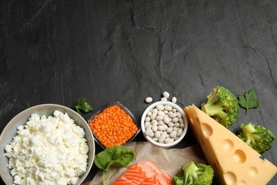 Photo of Products rich in protein on black table, flat lay. Space for text