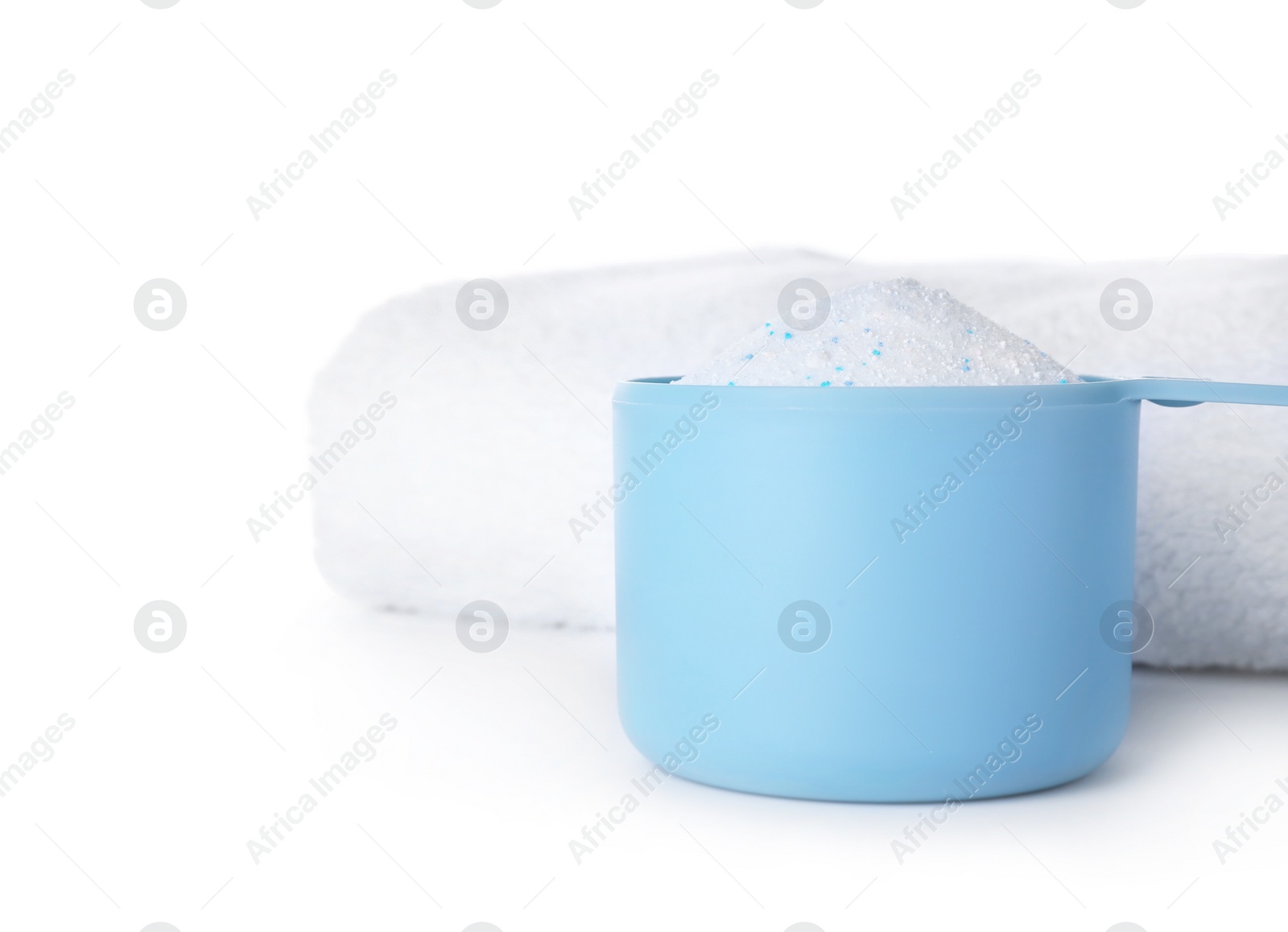 Photo of Laundry detergent in plastic measuring scoop and towel on white background