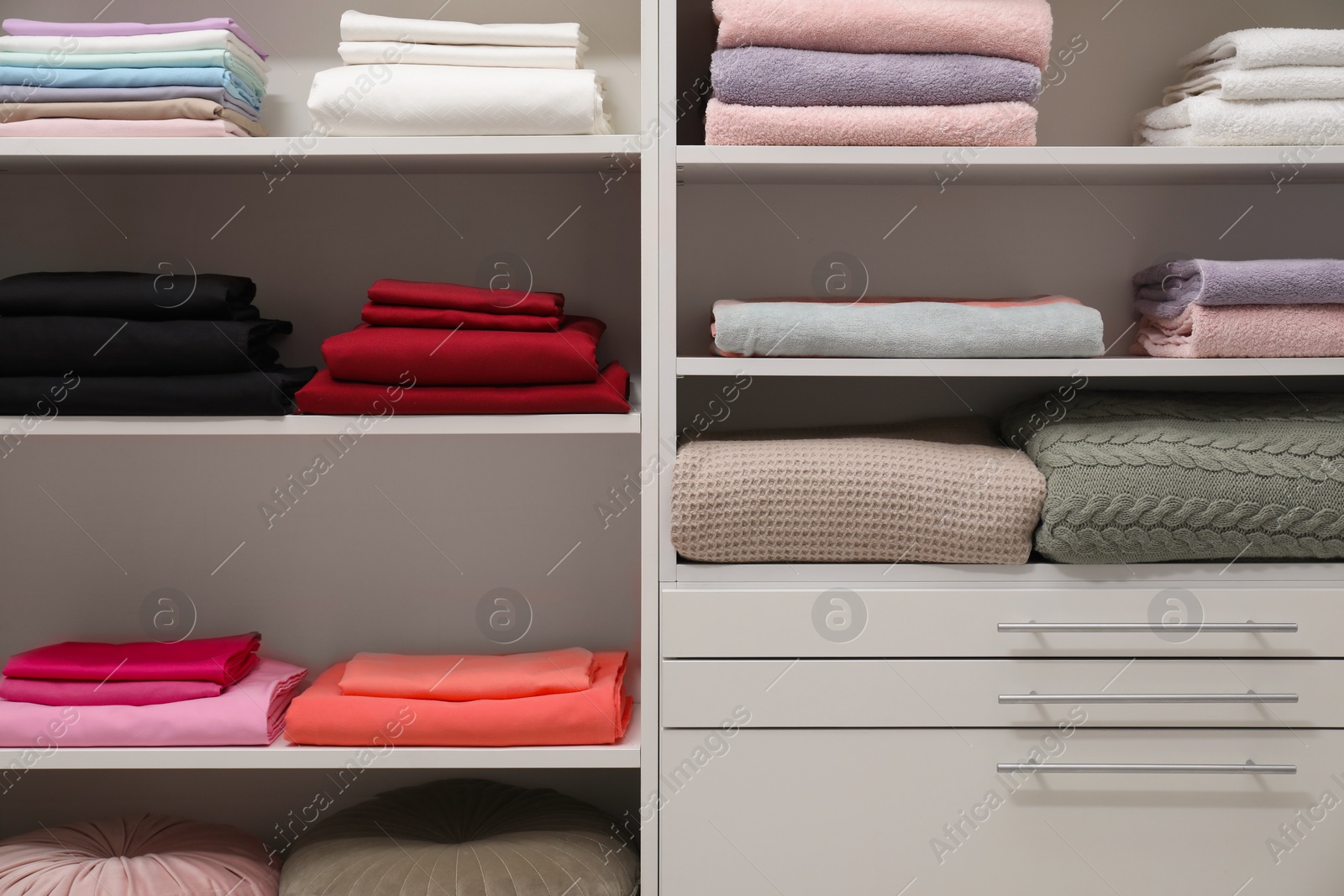 Photo of Different color linens on shelves in shop