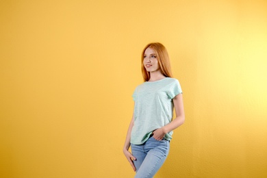 Photo of Young woman in stylish jeans on color background