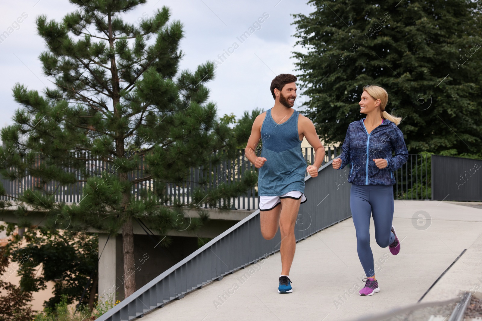 Photo of Healthy lifestyle. Happy sporty couple running outdoors, space for text