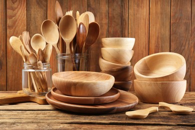 Many different wooden dishware and utensils on table