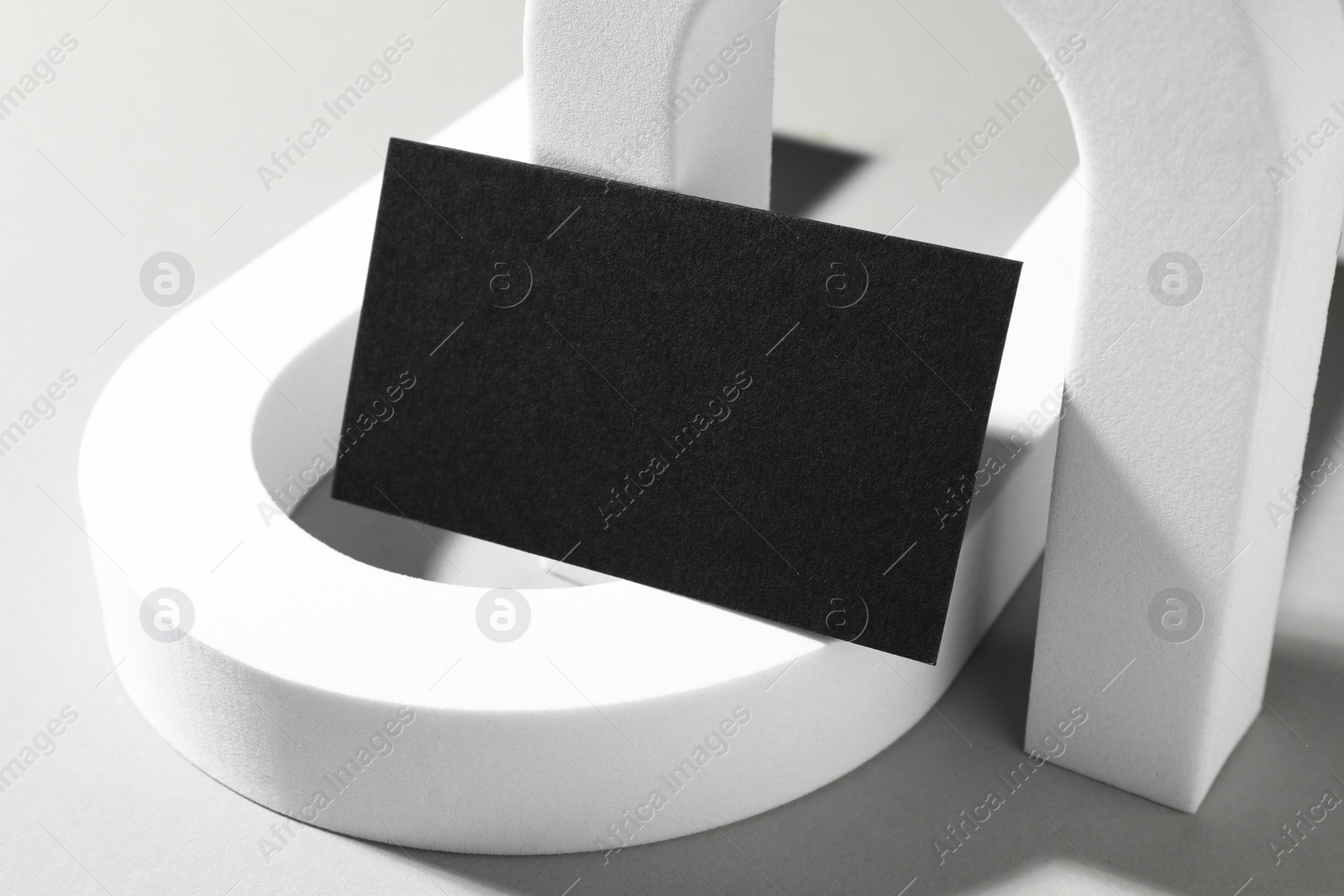 Photo of Empty black business card and decorative elements on white background. Mockup for design