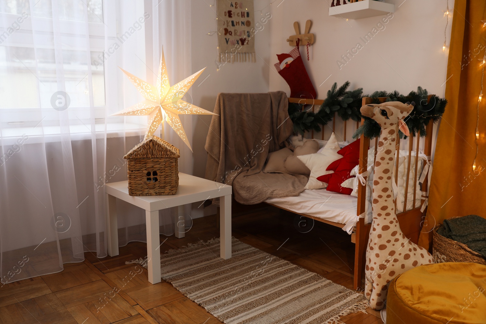 Photo of Cozy children's room with bed, toys and Christmas decor. Interior design