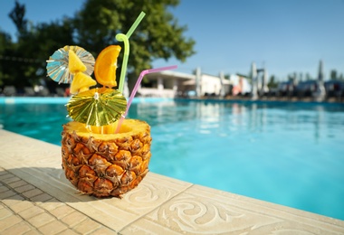 Tasty tropical cocktail on edge of swimming pool. Party drink