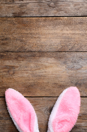 Photo of Decorative bunny ears and space for text on wooden background, flat lay. Easter holiday