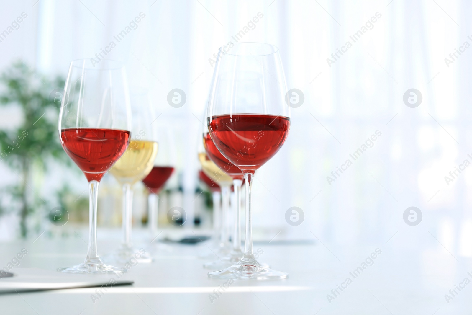 Photo of Glasses with delicious wine on table indoors