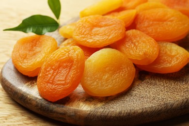 Photo of Tasty apricots on wooden table, closeup. Dried fruits