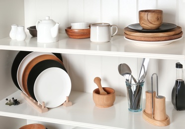 Photo of White shelving unit with set of dishware