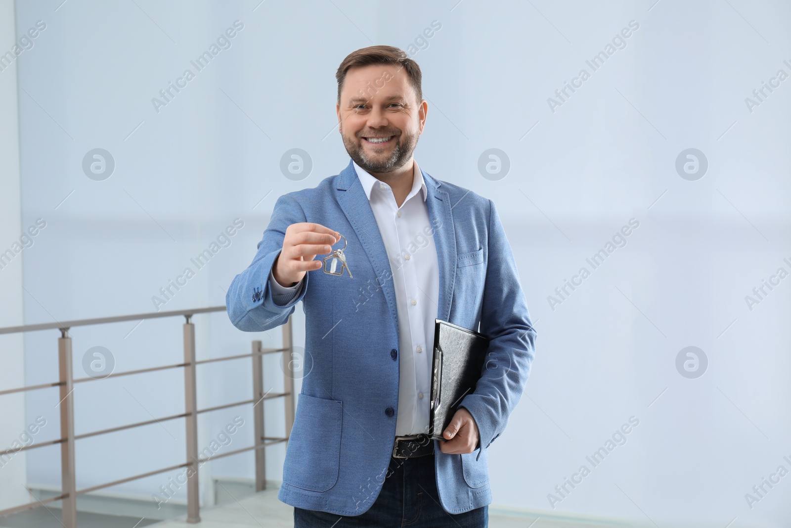 Photo of Male real estate agent holding key in new apartment