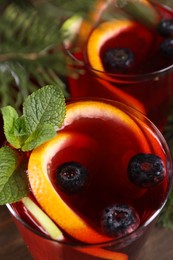 Aromatic Christmas Sangria drink in glasses on table, closeup