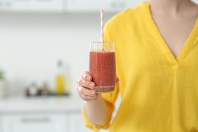 Photo of Woman with delicious smoothie in kitchen, closeup. Space for text