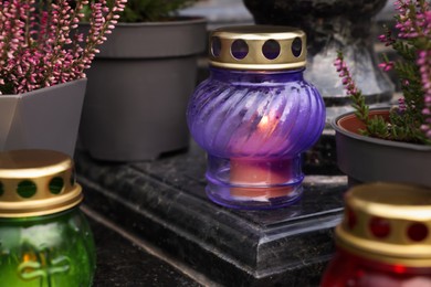 Photo of Different grave lanterns on granite surface at cemetery