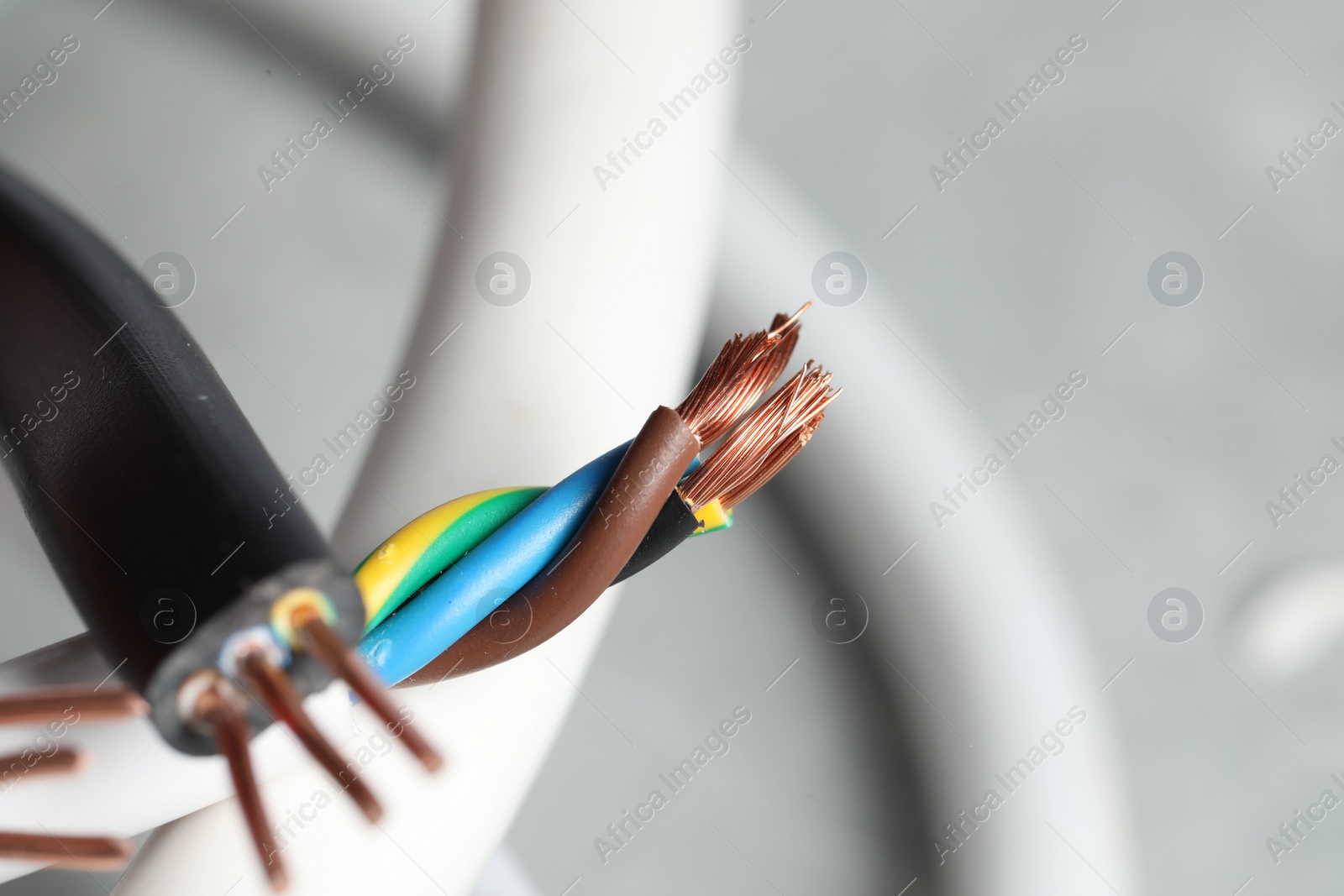 Photo of Colorful electrical wires on blurred background, closeup. Space for text