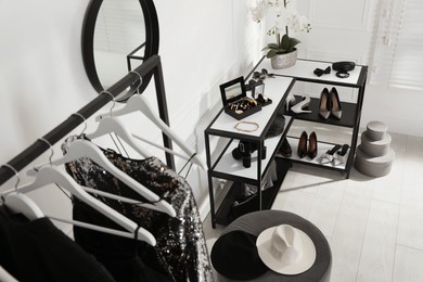 Photo of Shelving unit with stylish women's shoes, clothes and accessories in dressing room, above view