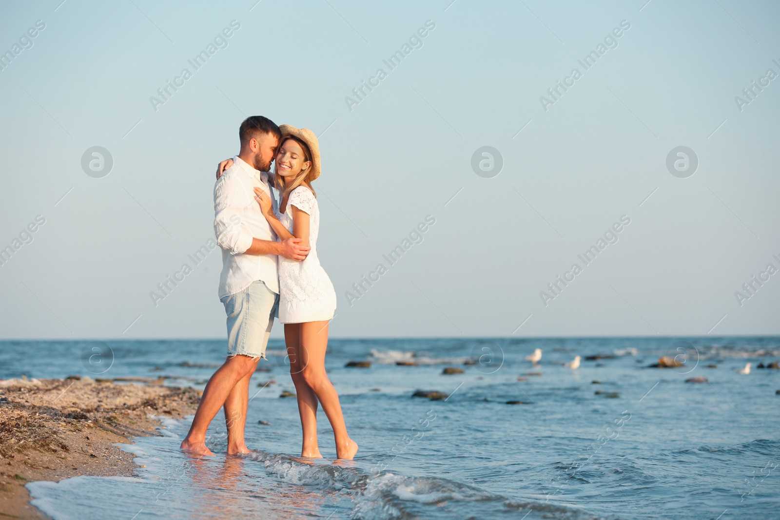 Photo of Young couple spending time together on beach