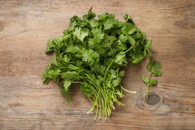 Bunch of fresh aromatic cilantro on wooden table, top view