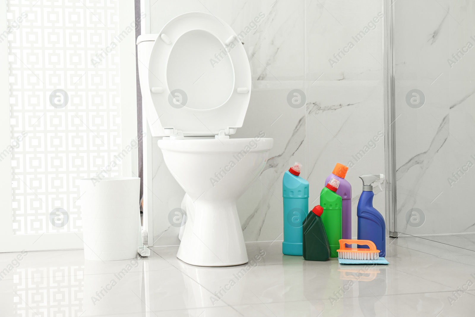 Photo of Toilet bowl and cleaning supplies in modern bathroom