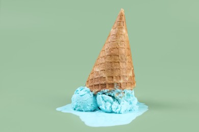 Photo of Melted ice cream and wafer cone on green background