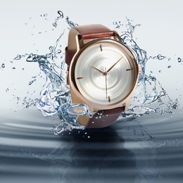 Luxury men's watch in water splashes demonstrating its waterproof