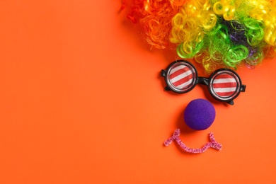 Photo of Funny face made with clown's accessories on red background, flat lay. Space for text