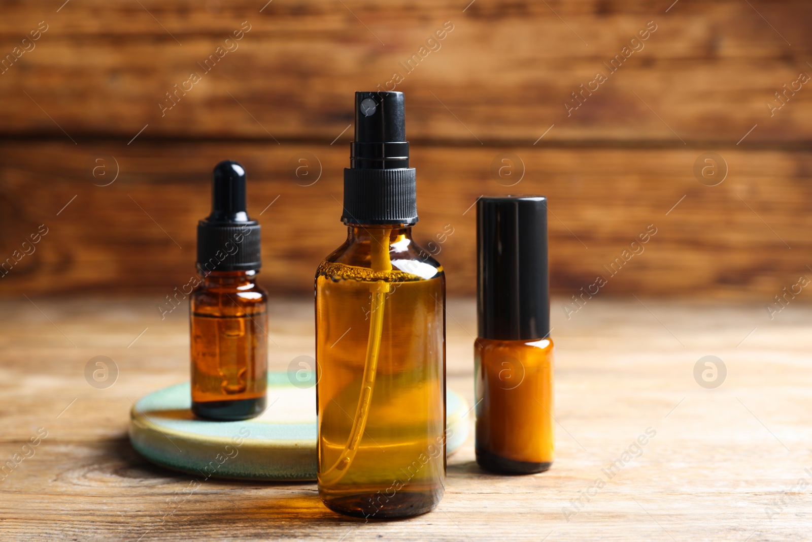 Photo of Bottles with oil on wooden table. Natural cosmetics