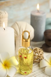 Photo of Bottle with essential oil on white wooden table. Spa product