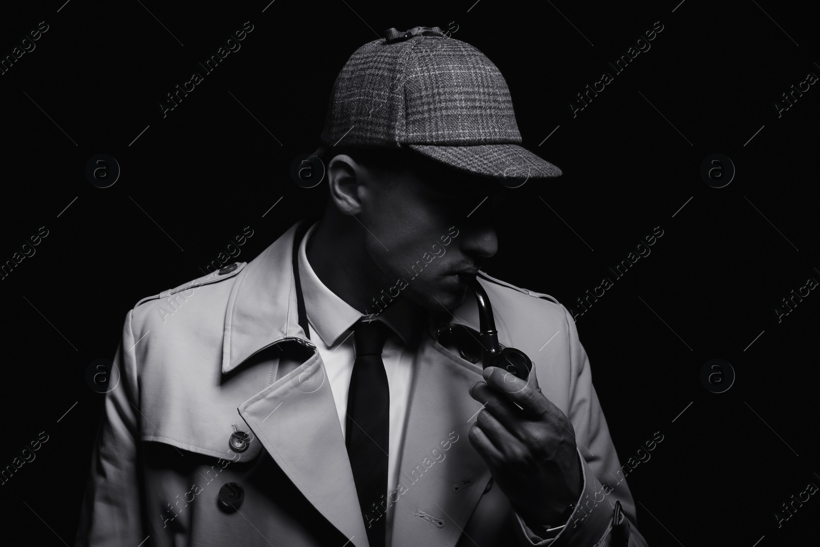 Photo of Old fashioned detective with smoking pipe on dark background, black and white effect