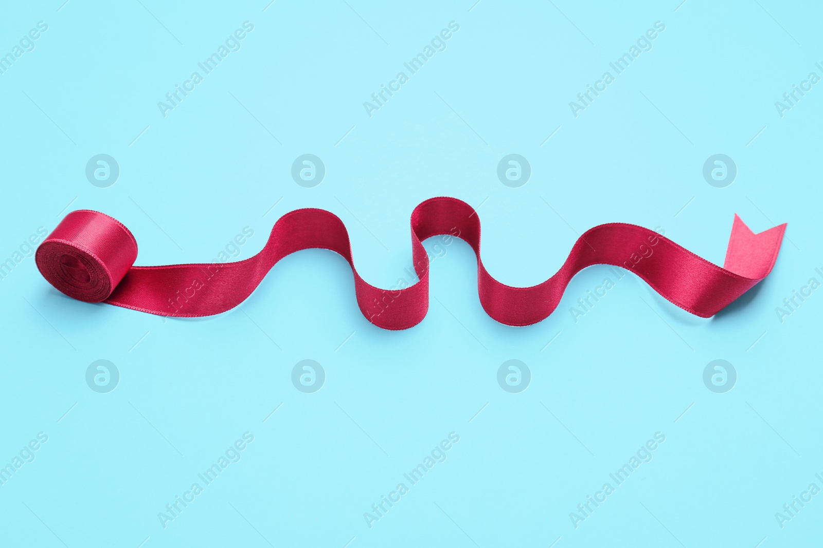 Photo of Simple pink ribbon on color background. Festive decoration