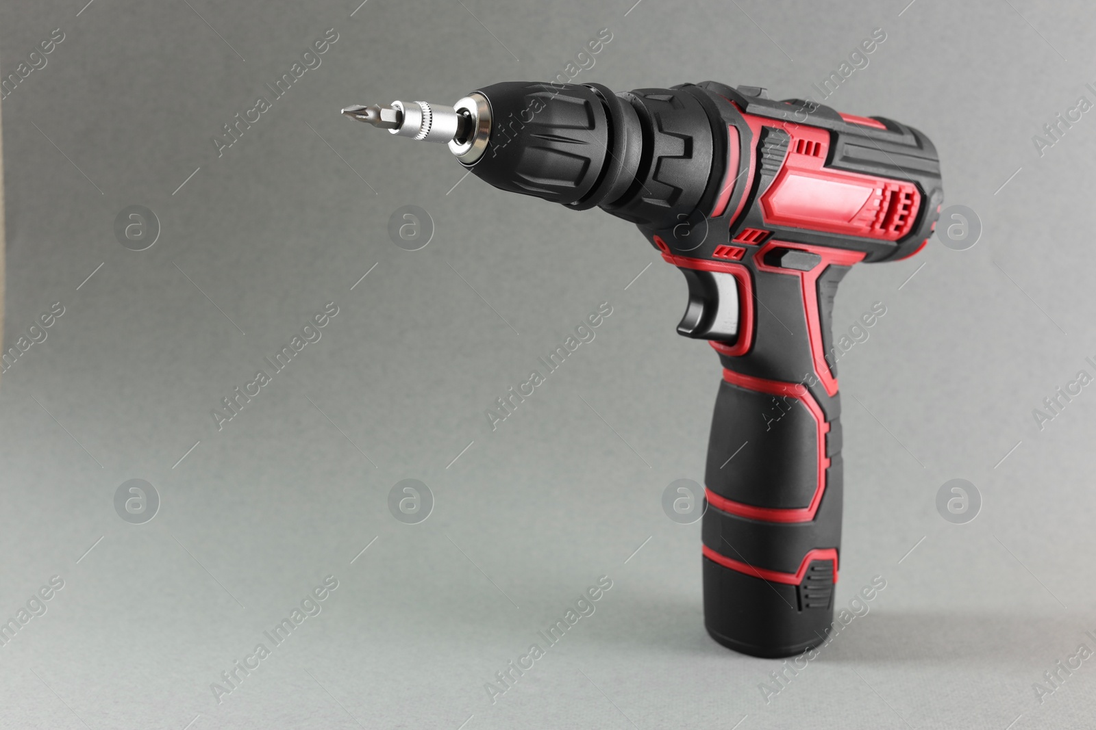 Photo of Modern cordless electric screwdriver on grey background. Space for text