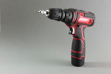 Modern cordless electric screwdriver on grey background. Space for text