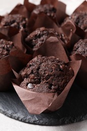 Tasty chocolate muffins on light table, closeup