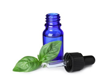 Little bottle of essential oil with dropper and basil on white background