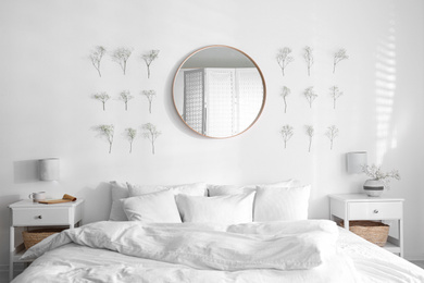 Modern bedroom interior with stylish round mirror